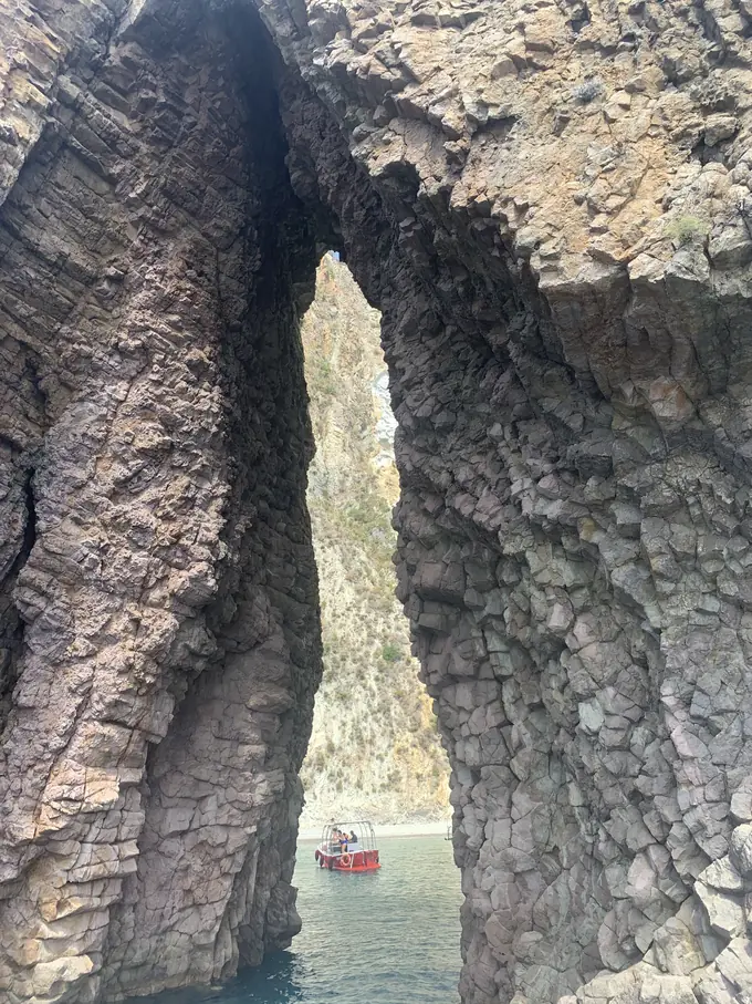 Piccola imbarcazione visibile attraverso l'Arco Naturale dell'isola di Ponza