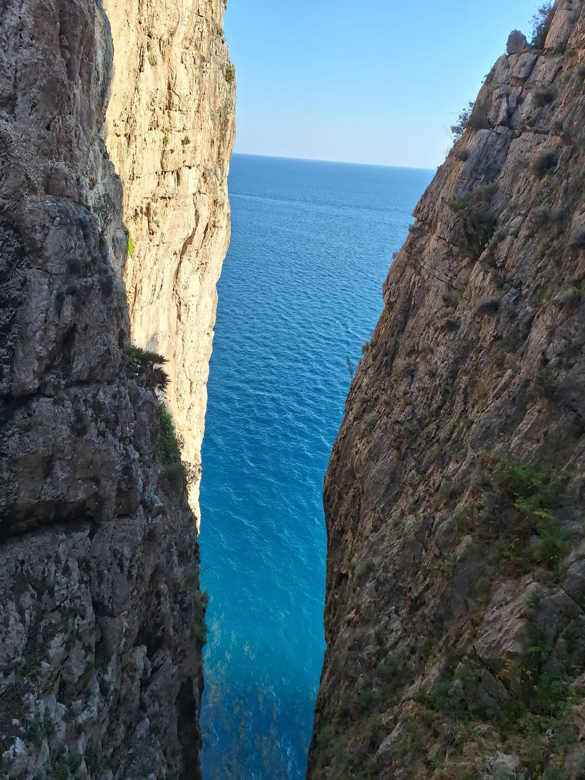 Fenditura verticale della Montagna Spaccata con il mare blu sottostante